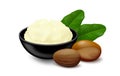 Shea butter in a black bowl with nuts and leaves isolated on white background